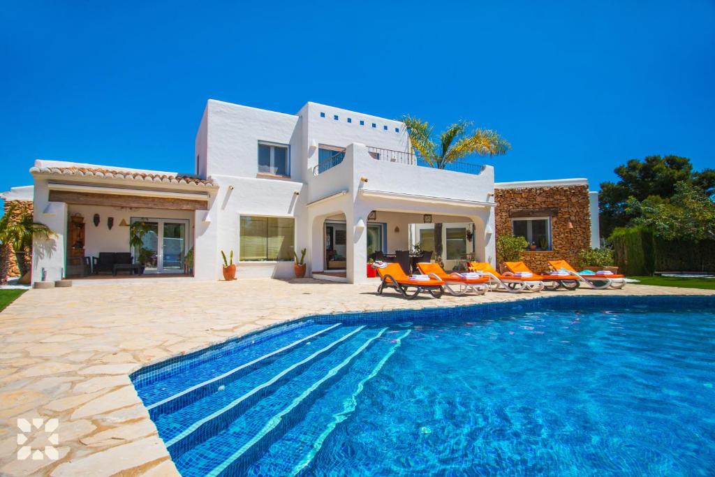 a villa with a swimming pool in front of a house at Villa Tuvalu by Abahana Luxe in Moraira