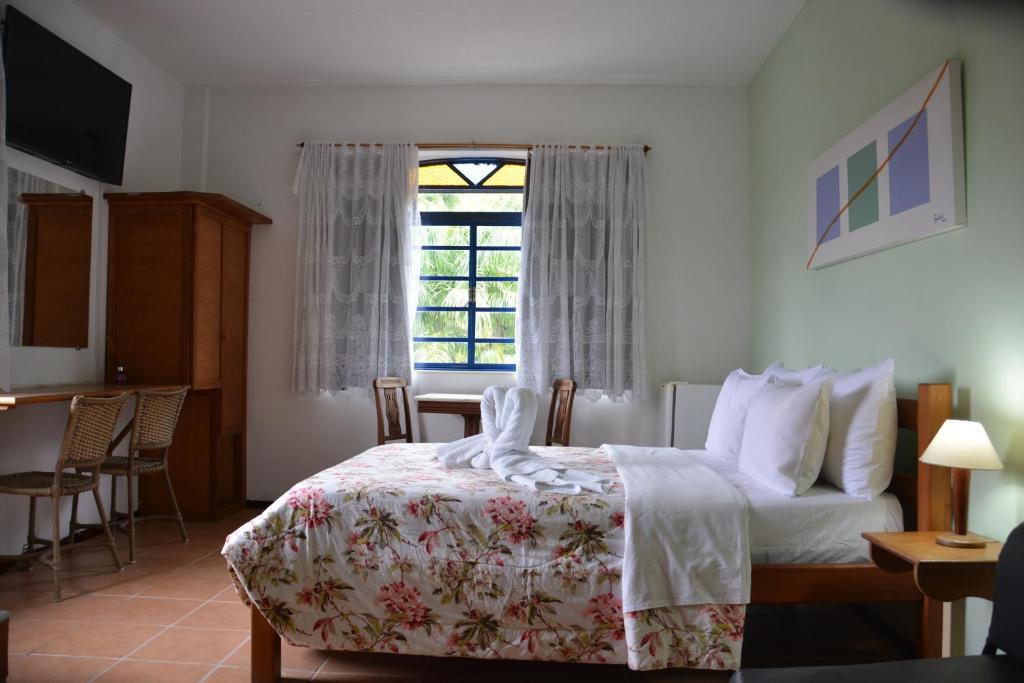 a hotel room with a bed and a window at Pousada 3 Corações in Penedo