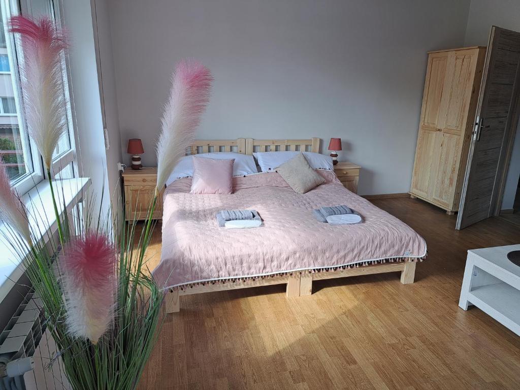 - une chambre avec un lit doté de couvertures et d'oreillers roses dans l'établissement Pokoje Bory Tucholskie, à Tuchola