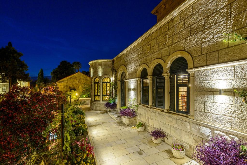a building with flowers in front of it at night at Villa Mediteran Old Town, 5 En-Suites and Hot Tub in Dubrovnik