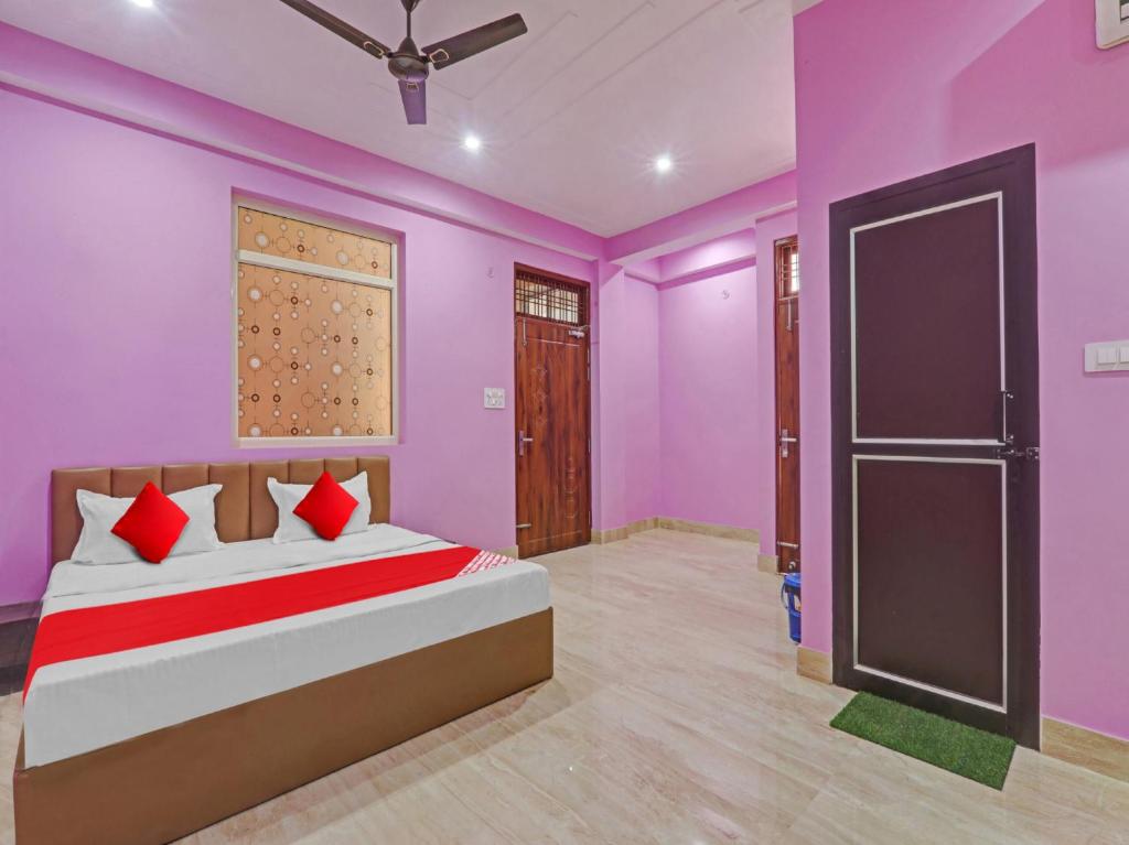 a bedroom with purple walls and a bed with a door at Srv Inn in Nilmatha
