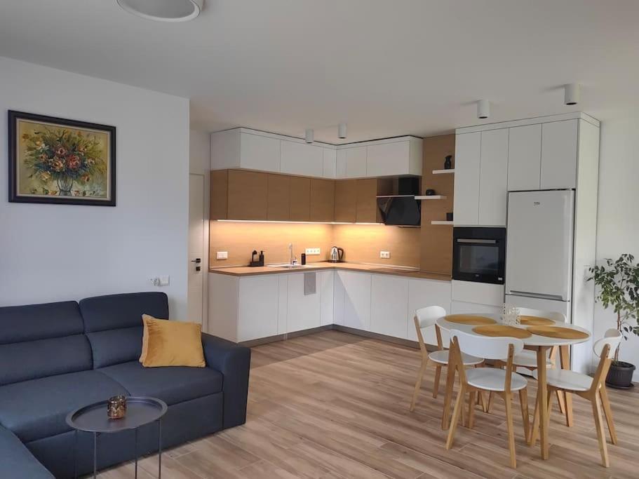 ein Wohnzimmer mit einem blauen Sofa und einem Tisch in der Unterkunft The Courtyard 2Bdrm Apartment in Sofia