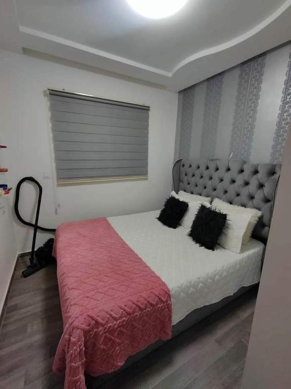 a bedroom with a large bed with a red blanket at إقامة دشيرا الجديدة جهادية in Dcheira El Jihadia