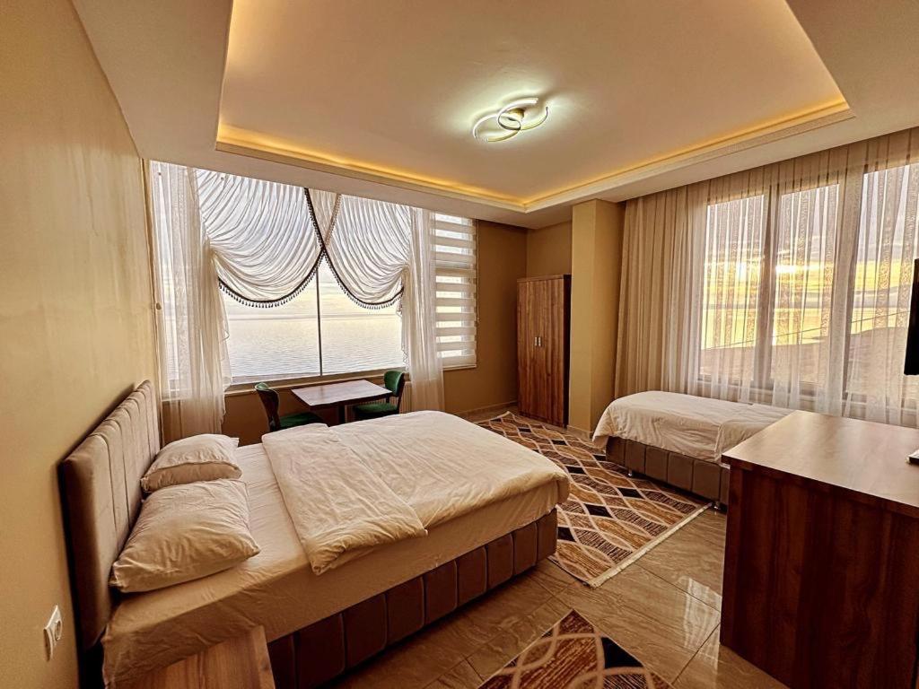 Erkizan的住宿－Ahlat 1071 Otel&Restaurant，一间卧室设有两张床和窗户。