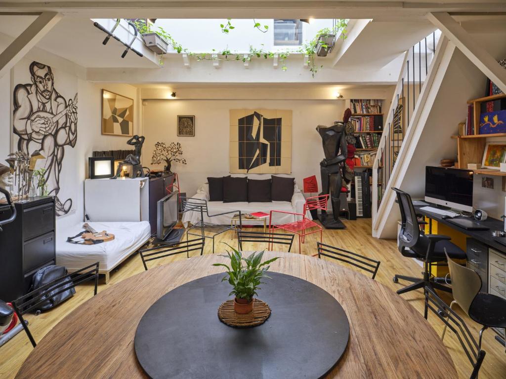 un salon avec une table et des chaises dans l'établissement Atelier d'artiste en plein Paris, à Paris