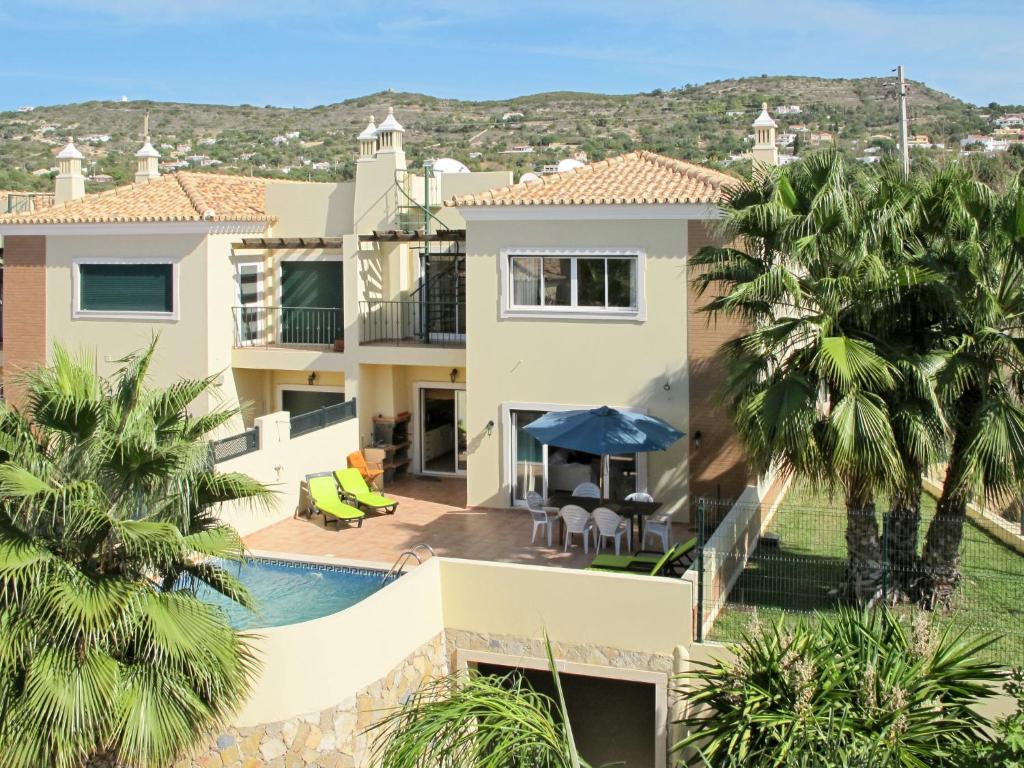 uma villa com piscina e palmeiras em Holiday Home Quinta da Fonte - SBN201 by Interhome em Santa Bárbara de Nexe