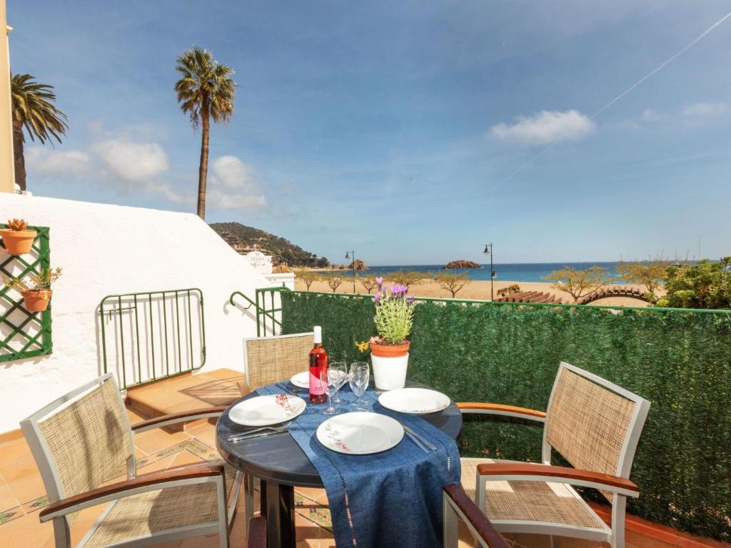 a table and chairs on a patio with a view of the ocean at Apartment Baldri by Interhome in Tossa de Mar