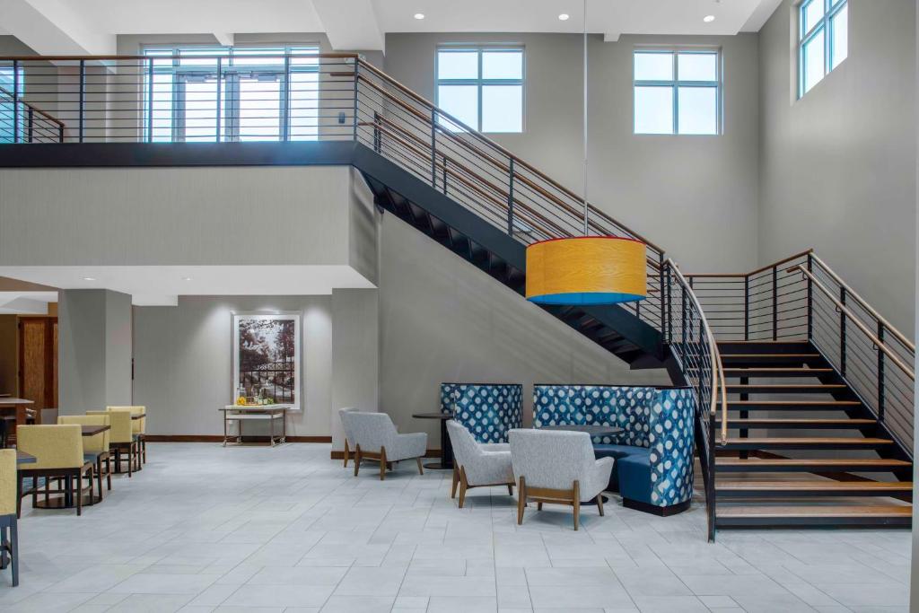 a lobby with stairs and tables and chairs at Hilton Garden Inn Charleston / Mt. Pleasant in Charleston