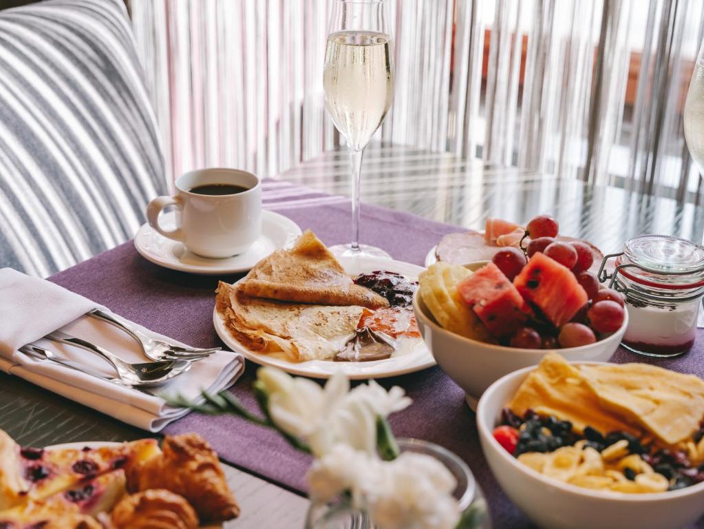 a table with plates of food and a cup of coffee at Grand Hotel Lviv Casino & Spa in Lviv