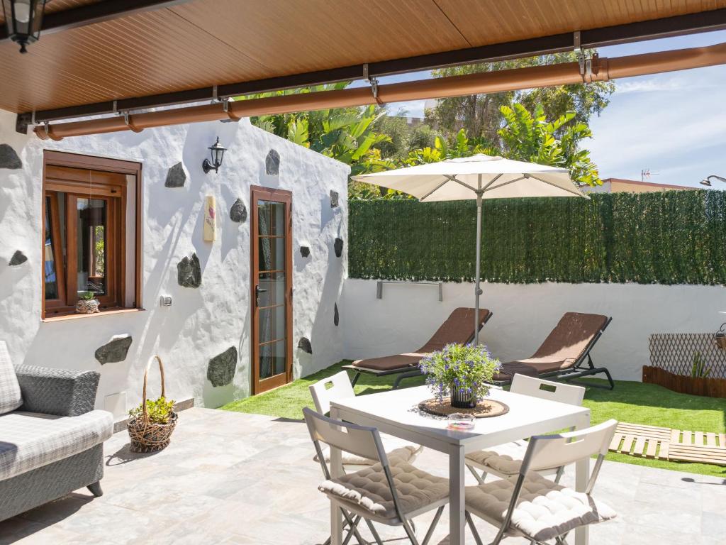 une terrasse avec une table et un parasol dans l'établissement Holiday Home Mamasica by Interhome, à Ingenio