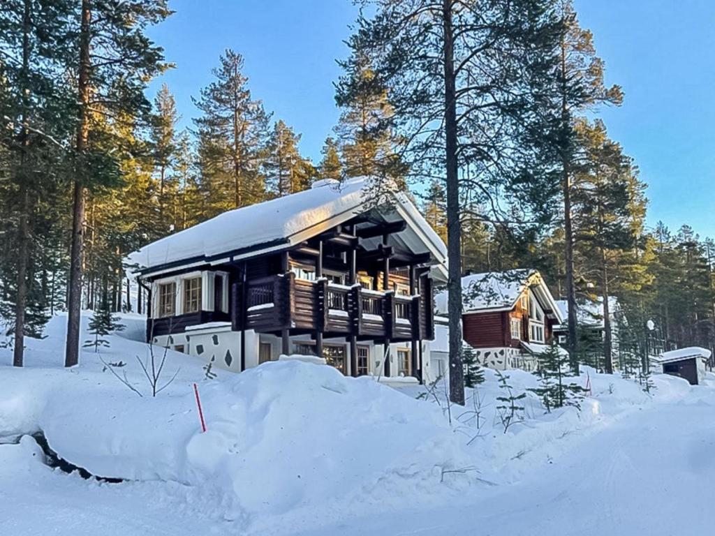 una casa está cubierta de nieve con árboles en Holiday Home Estrella levi by Interhome, en Levi