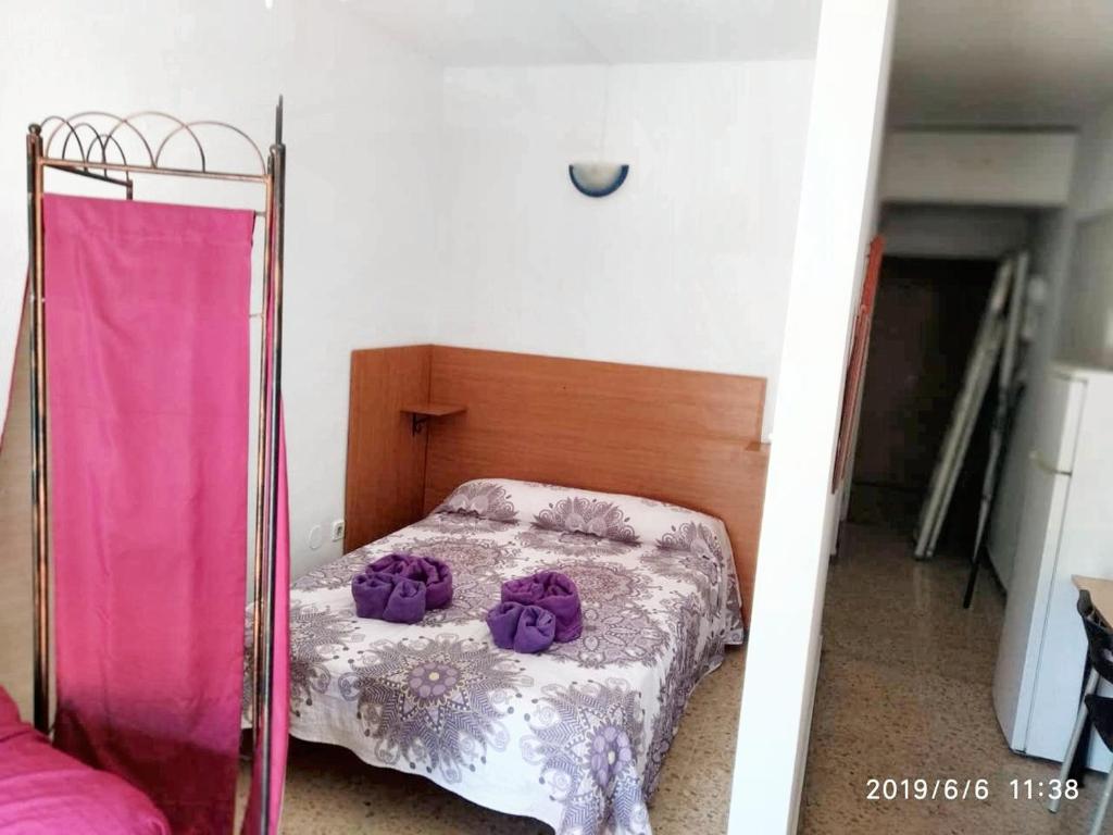 ein Schlafzimmer mit einem Bett mit lila Blumen darauf in der Unterkunft Studio with wifi at Torremolinos 1 km away from the beach in Torremolinos