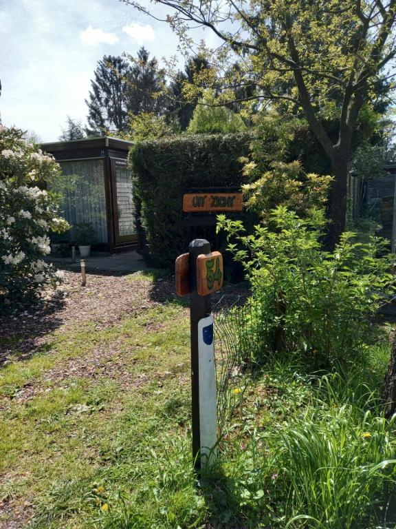 a parking meter in the grass with a street sign at Chalet "Uit Zicht" in Putten