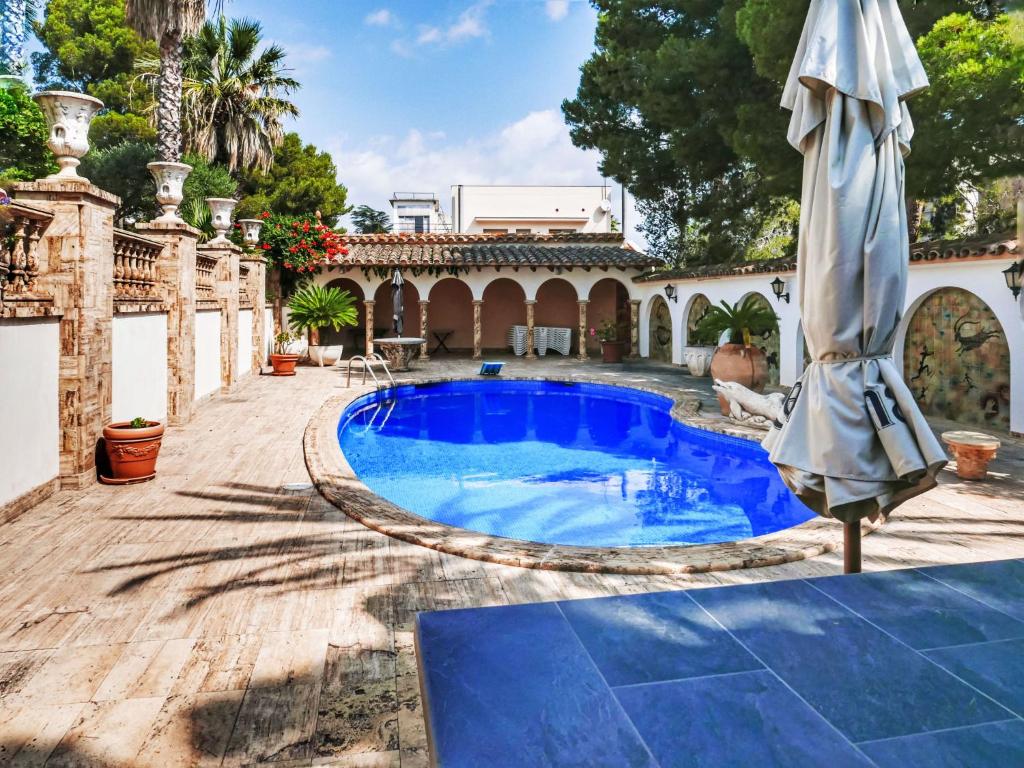 un ombrellone e una piscina in un cortile di Villa Les Oliveres by Interhome a Llança