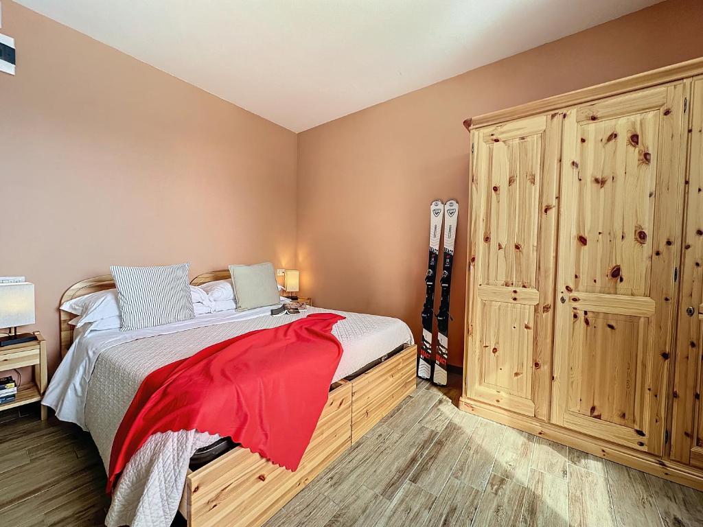 - une chambre avec un lit et une grande armoire en bois dans l'établissement Albergo Rifugio La Grande Baita, à Cutigliano