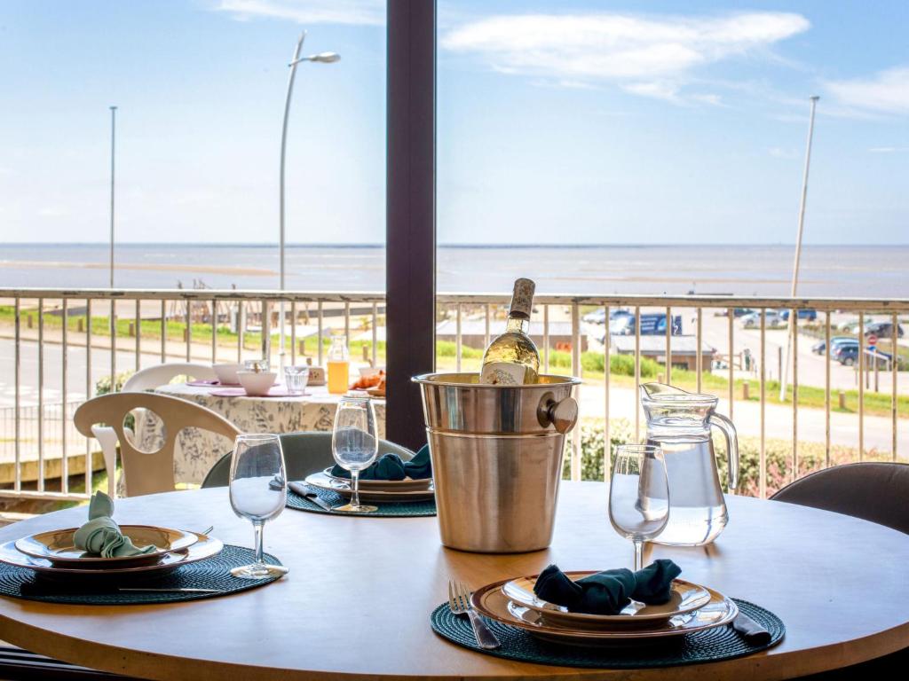 a table with glasses and a bottle of wine on it at Apartment Le Bellevue by Interhome in Saint-Brevin-les-Pins