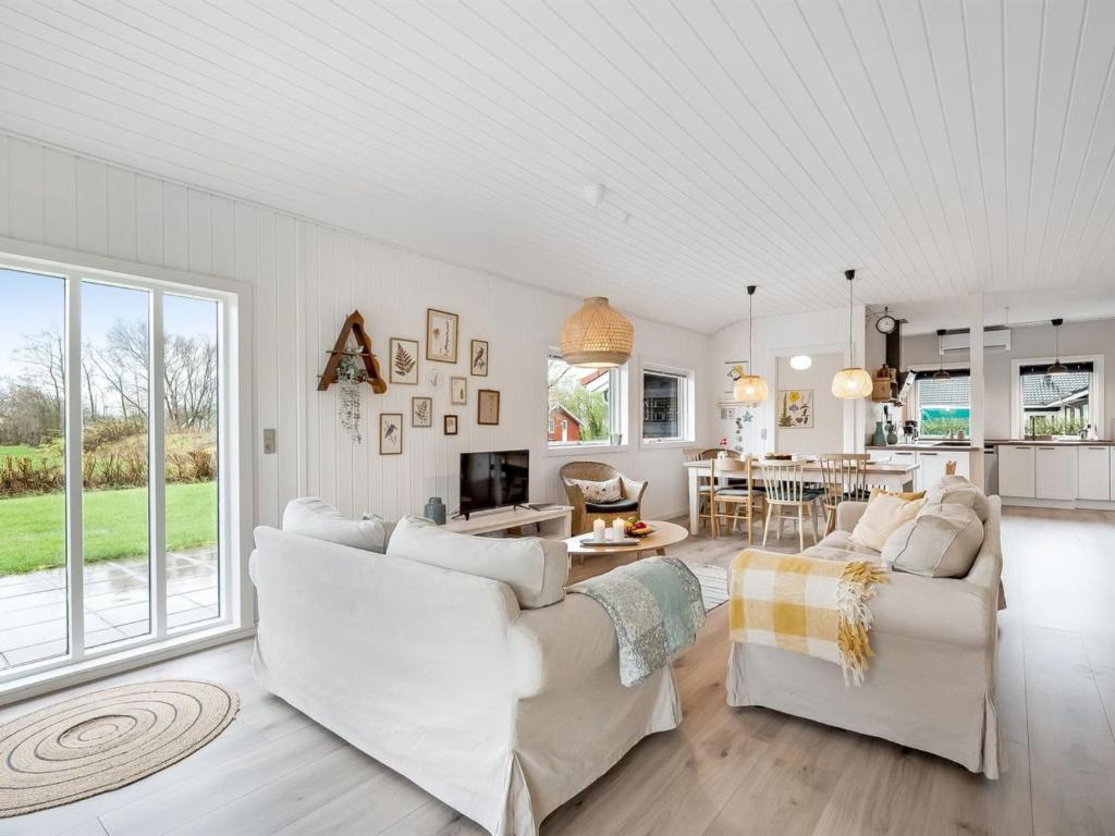uma sala de estar com dois sofás brancos e uma cozinha em Holiday Home Blakke - all inclusive - 850m to the inlet by Interhome em Hemmet