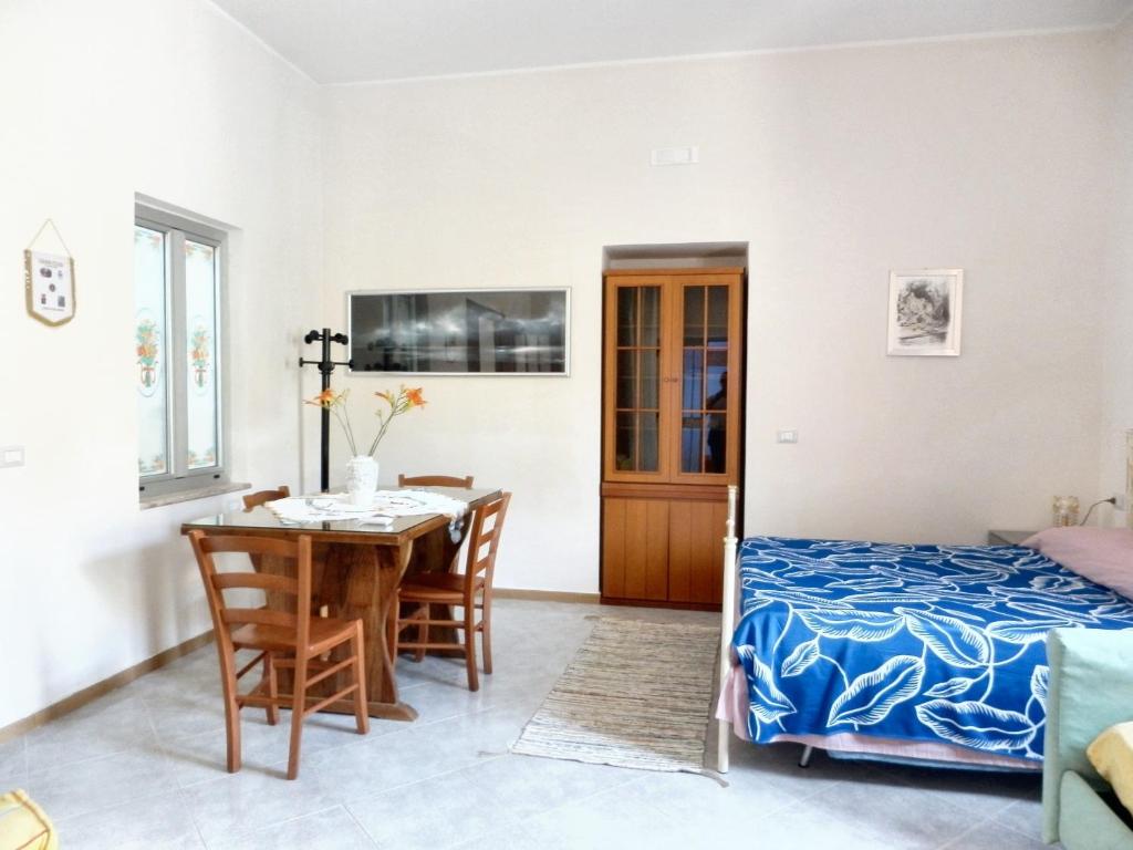 1 dormitorio con 1 cama, mesa y sillas en Studio with terrace at Formicola, en Formicola