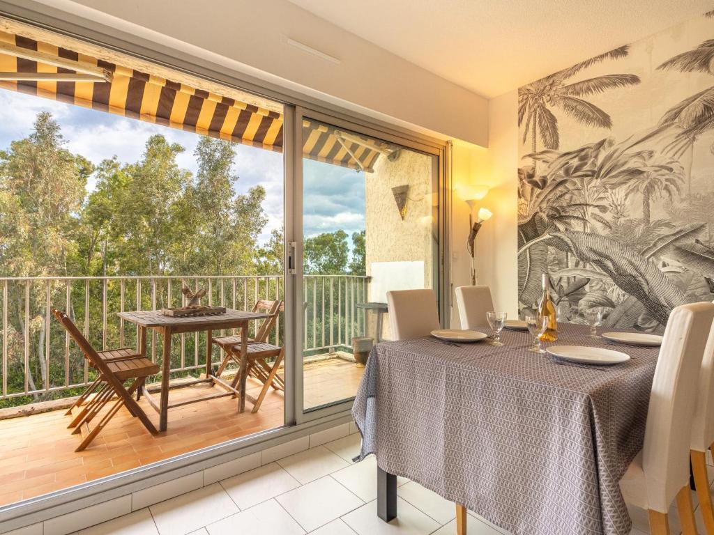 a dining room with a table and a balcony at Apartment Le Grand Large-2 by Interhome in Hyères
