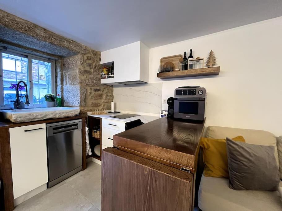 Una cocina con una encimera y un sofá dentro. en Casa centro histórico Vilanova, en Villanueva de Arosa