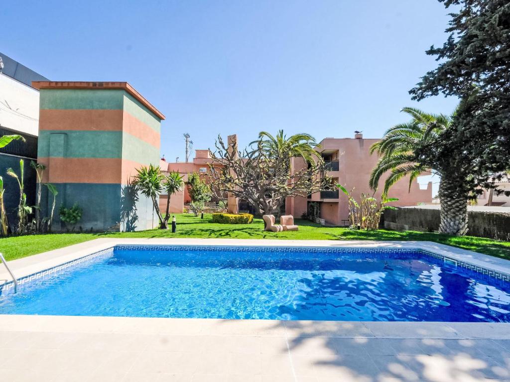 a swimming pool in front of a house at Apartment Playa Tarraco-2 by Interhome in Tarragona