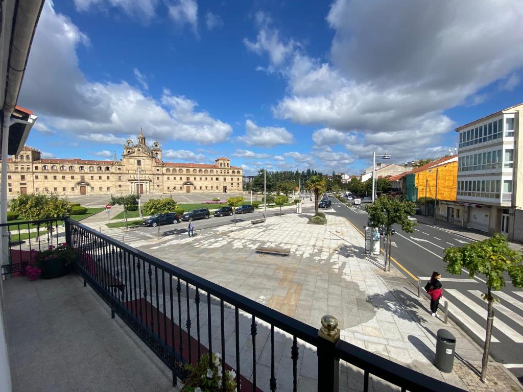 a woman walking down a street in front of a building at Campo de la Compañía in Monforte de Lemos