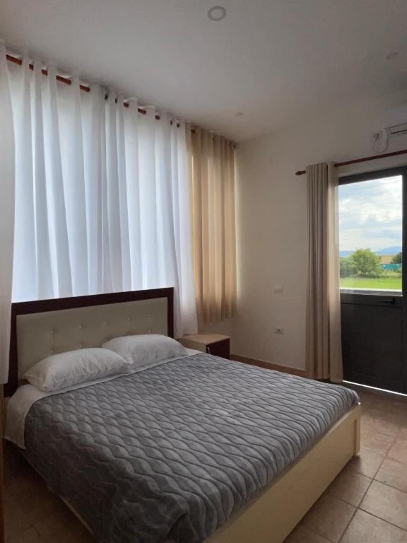 - une chambre avec un lit et une grande fenêtre dans l'établissement Hostel Internacional, à Grilë