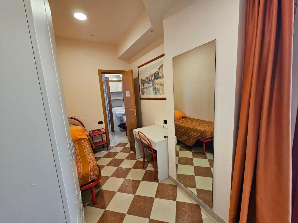 een kleine kamer met een dambordvloer bij Hotel Fiorella in Senigallia