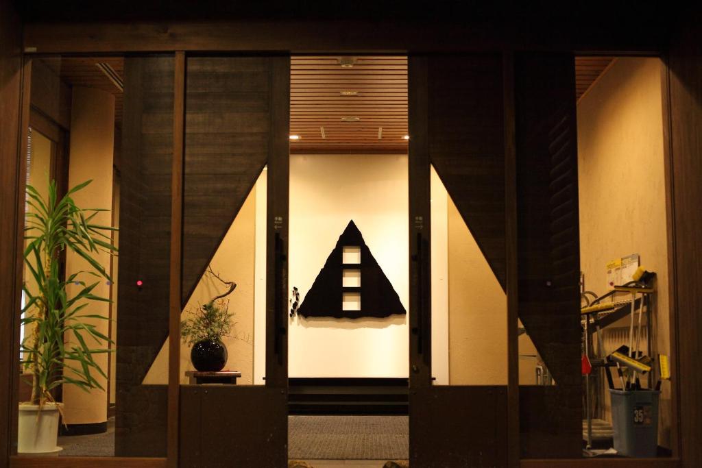 a hallway with a black and white sign on the wall at TOYOTA Shirakawa-Go Eco-Institute in Shirakawa