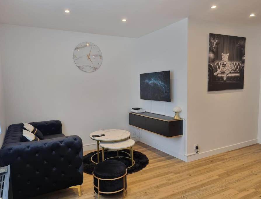 - un salon avec un canapé, une table et un réveil dans l'établissement apparemment cosy & chic, à Rezé