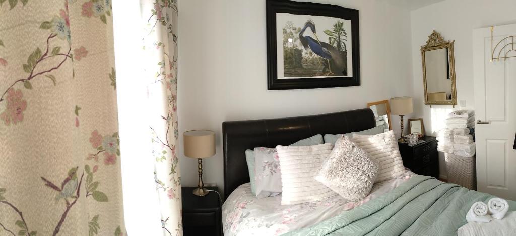 Schlafzimmer mit einem Bett mit einem schwarzen Kopfteil und weißen Kissen in der Unterkunft House Rose 1 in Prescot