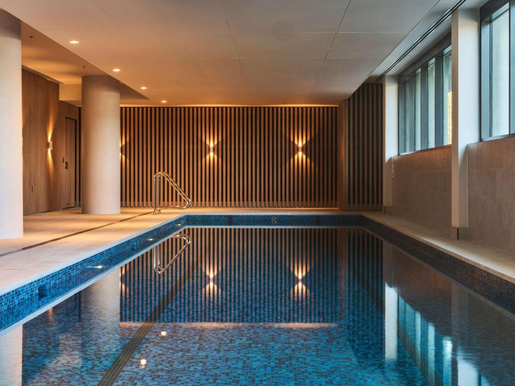 a swimming pool in a hotel with lights on the wall at Novotel Melbourne Airport in Melbourne