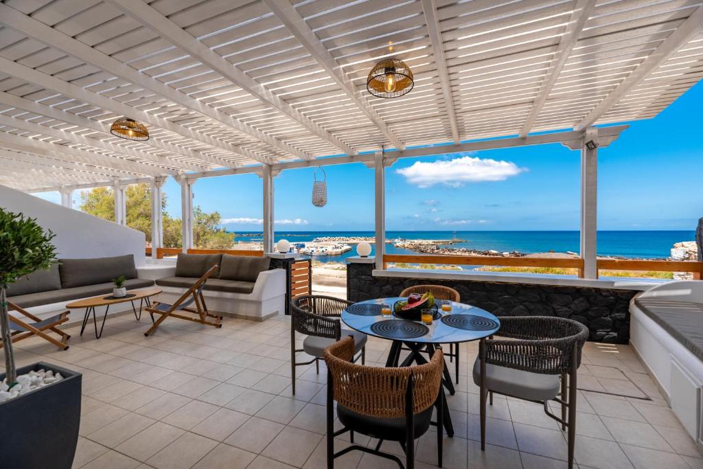 a patio with tables and chairs and a view of the ocean at Gabriel House in Monolithos