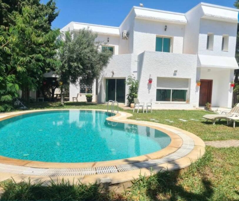 a swimming pool in front of a house at Villa à yasmine hammamet in Nabeul