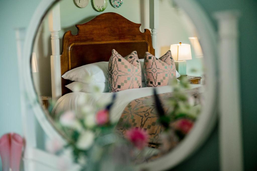 um reflexo de uma cama com almofadas no espelho em Sweeney Hall Hotel em Oswestry