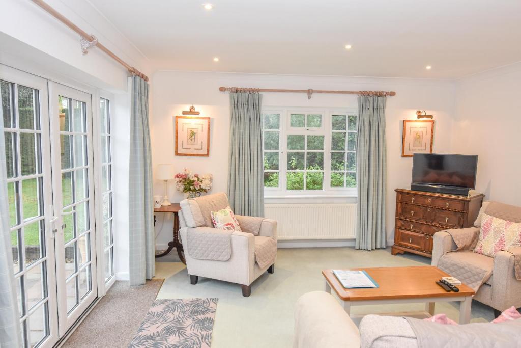White Roses في بيمبريدج: غرفة معيشة مع أريكة وكراسي وتلفزيون