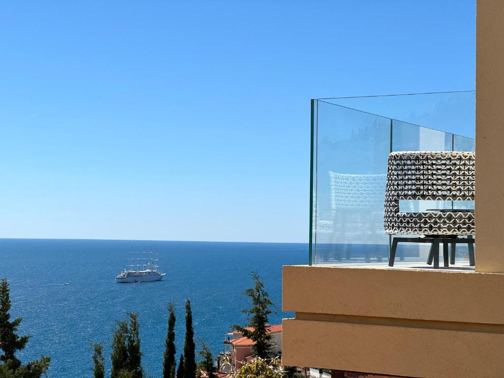 Una silla colocada en lo alto de un edificio con vistas al océano. en MyBlueVista LUXURY WELLNESS VILLA La Mer NEAR MONACO, en Roquebrune-Cap-Martin