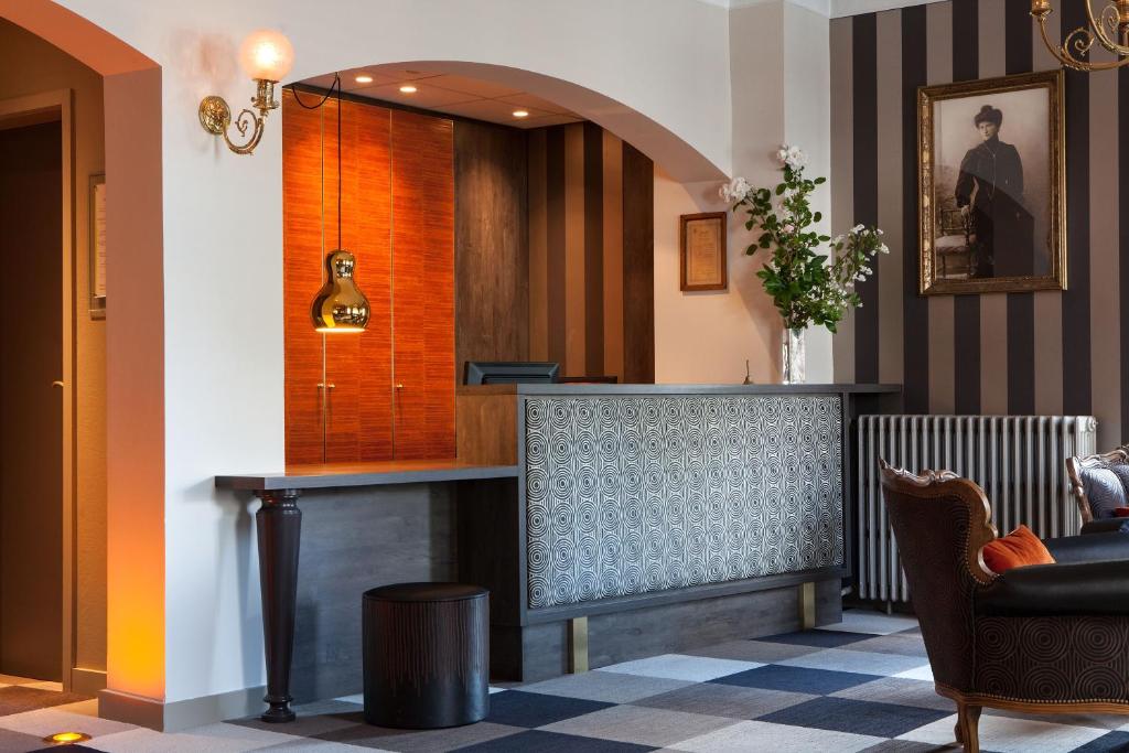 a lobby with a bar with a mirror at Logis Hôtel Beauséjour Colmar in Colmar