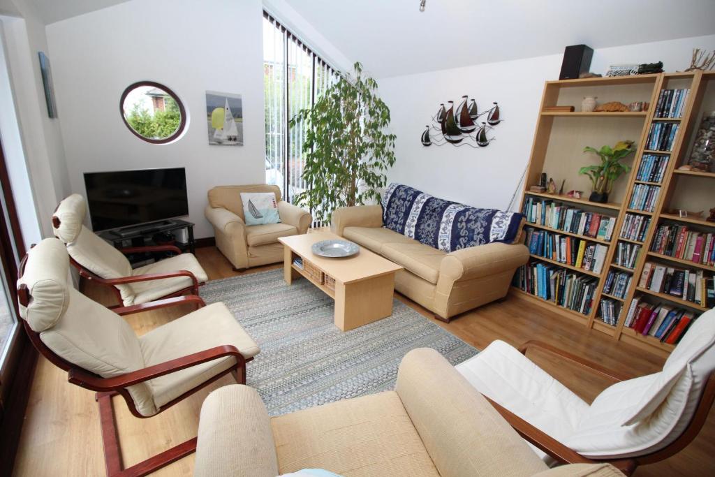 ein Wohnzimmer mit einem Sofa, Stühlen und einem TV in der Unterkunft Acer in Corfe Mullen