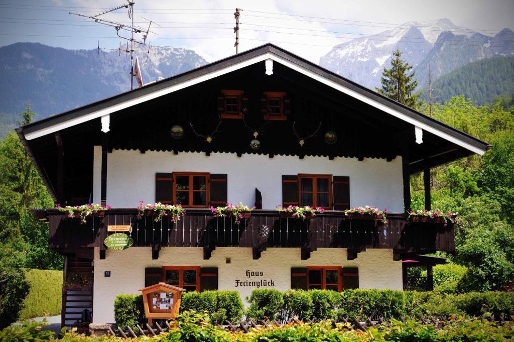 een huis met een balkon met bloemen erop bij Haus Ferienglück in Schönau am Königssee