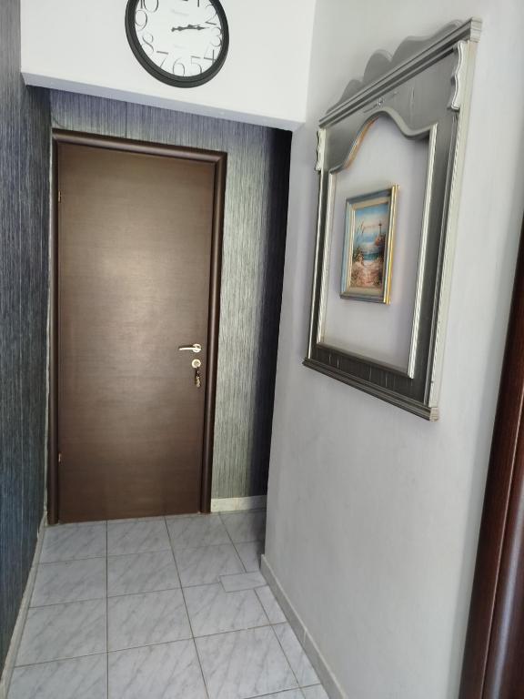 a hallway with a door and a clock on the wall at AlenStudios in Paralia Katerinis