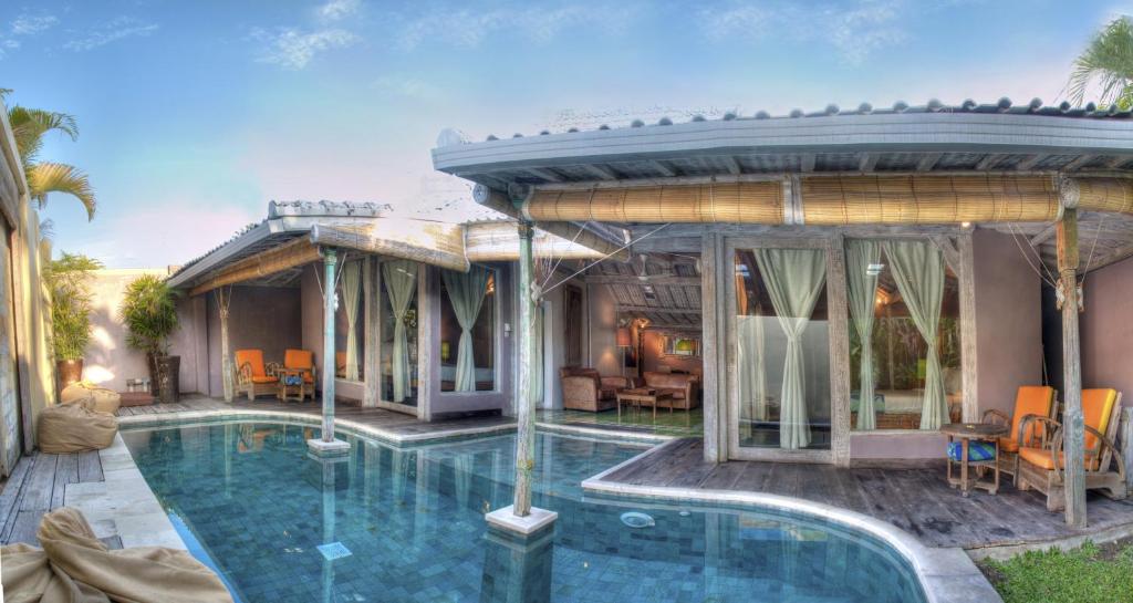 a home with a swimming pool and a house at Villa West - Charming 2 bdr villa in Oberoi - PERFECT LOCATION! in Seminyak