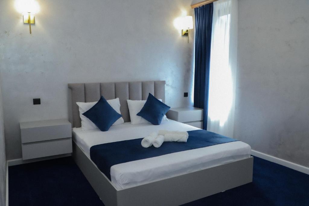 um quarto com uma cama com almofadas azuis e brancas em Central hotel em Meghri