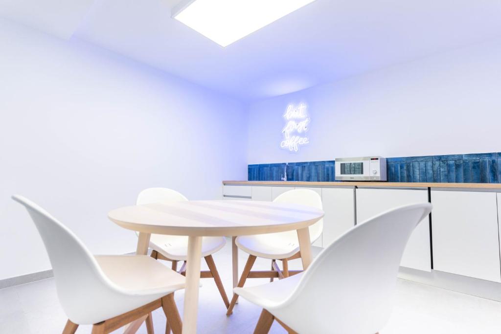 a white kitchen with a table and white chairs at Esmeralda Cotillo Homes by LIVVO in El Cotillo