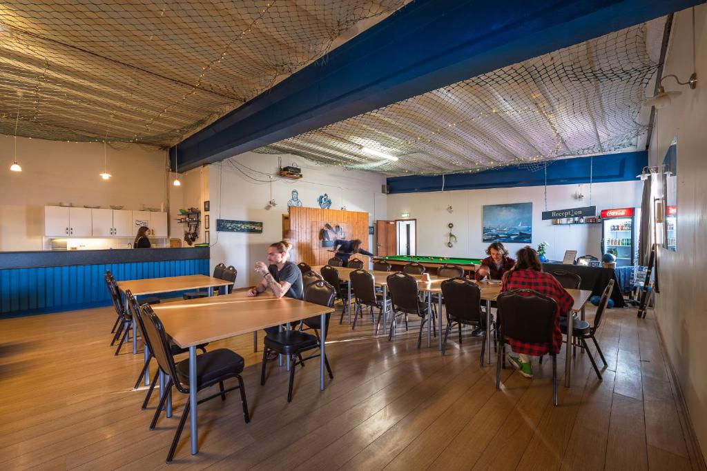 un grupo de personas sentadas en mesas en un restaurante en Fisherinn, Hostel and Cultural Center en Stokkseyri