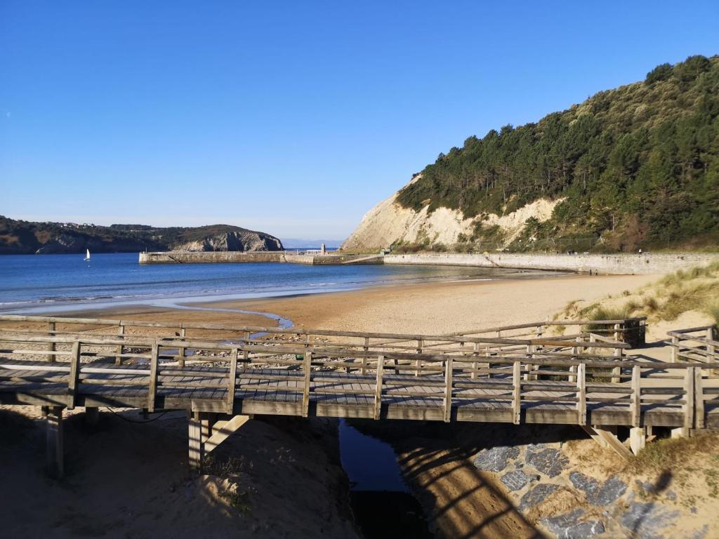 a wooden bridge over a beach with the ocean at Ático con 2 terrazas, 25m2 cada una By urban hosts in Górliz-Elexalde