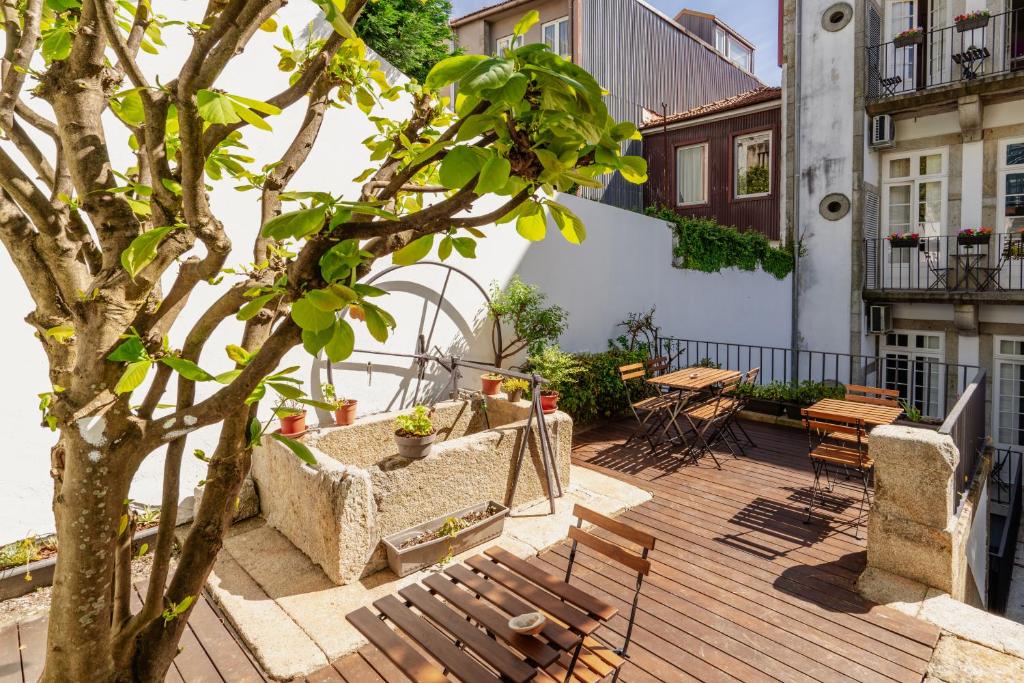 une terrasse en bois avec des bancs et un arbre dans l'établissement Porto Lounge Hostel & Guesthouse by Host Wise, à Porto