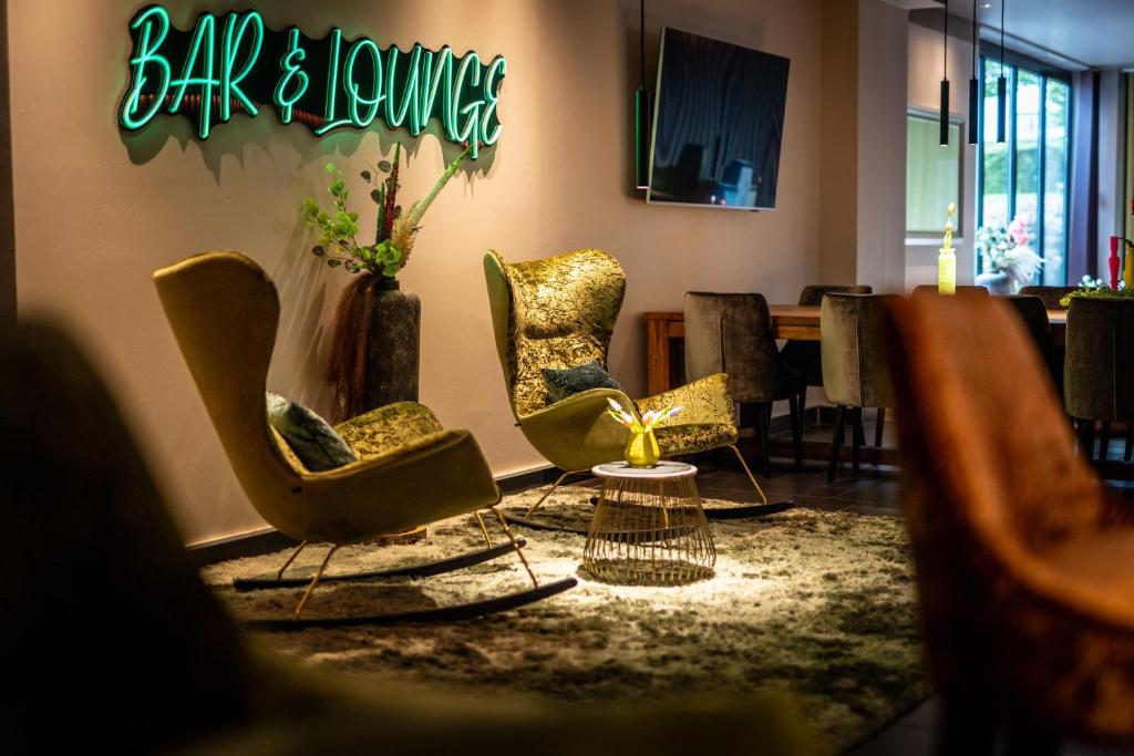 ein Zimmer mit Stühlen und ein Schild mit Bar und Lounge in der Unterkunft Friendly Cityhotel Oktopus in Siegburg