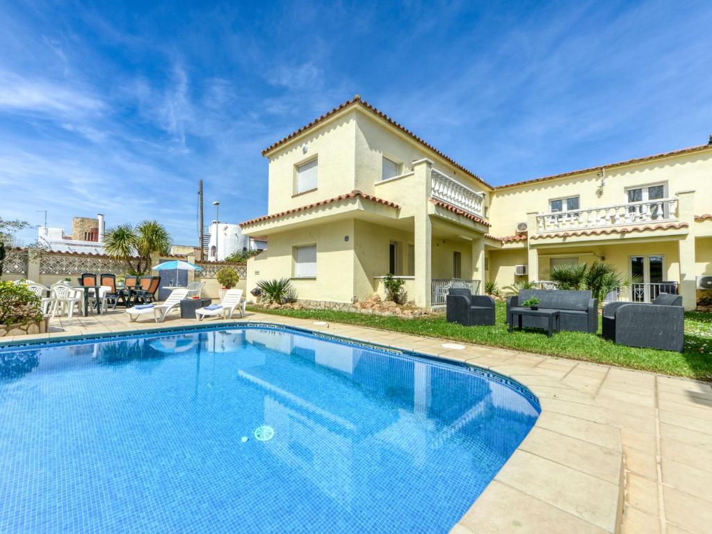 a swimming pool in front of a house at Apartment Muga-2 by Interhome in Empuriabrava