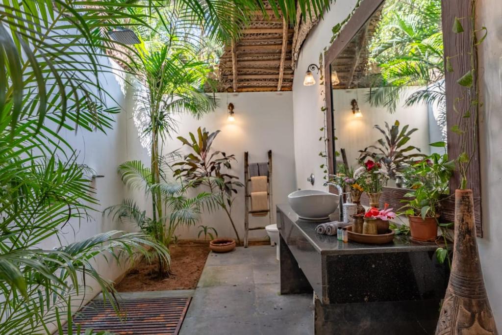 a bathroom with a sink and a bunch of plants at The Bay Agonda in Agonda